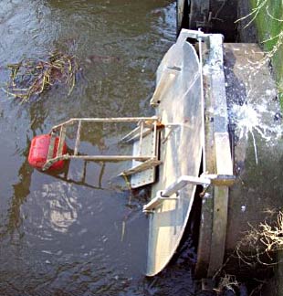 Figure 1. Automatic tidal floodgates consist of a mini-floodgate within a normal flapgate. The floating arm closes the mini-floodgate as the tide rises, controlling drain water levels and preventing overtopping (Photo: Frederieke Kroon) Figure 1. Automatic tidal floodgates consist of a mini-floodgate within a normal flapgate. The floating arm closes the mini-floodgate as the tide rises, controlling drain water levels and preventing overtopping (Photo: Frederieke Kroon)