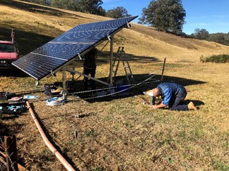 Solar powered irrigation system installation solar powered irrigation system being set up solar panels and equipment on farm field